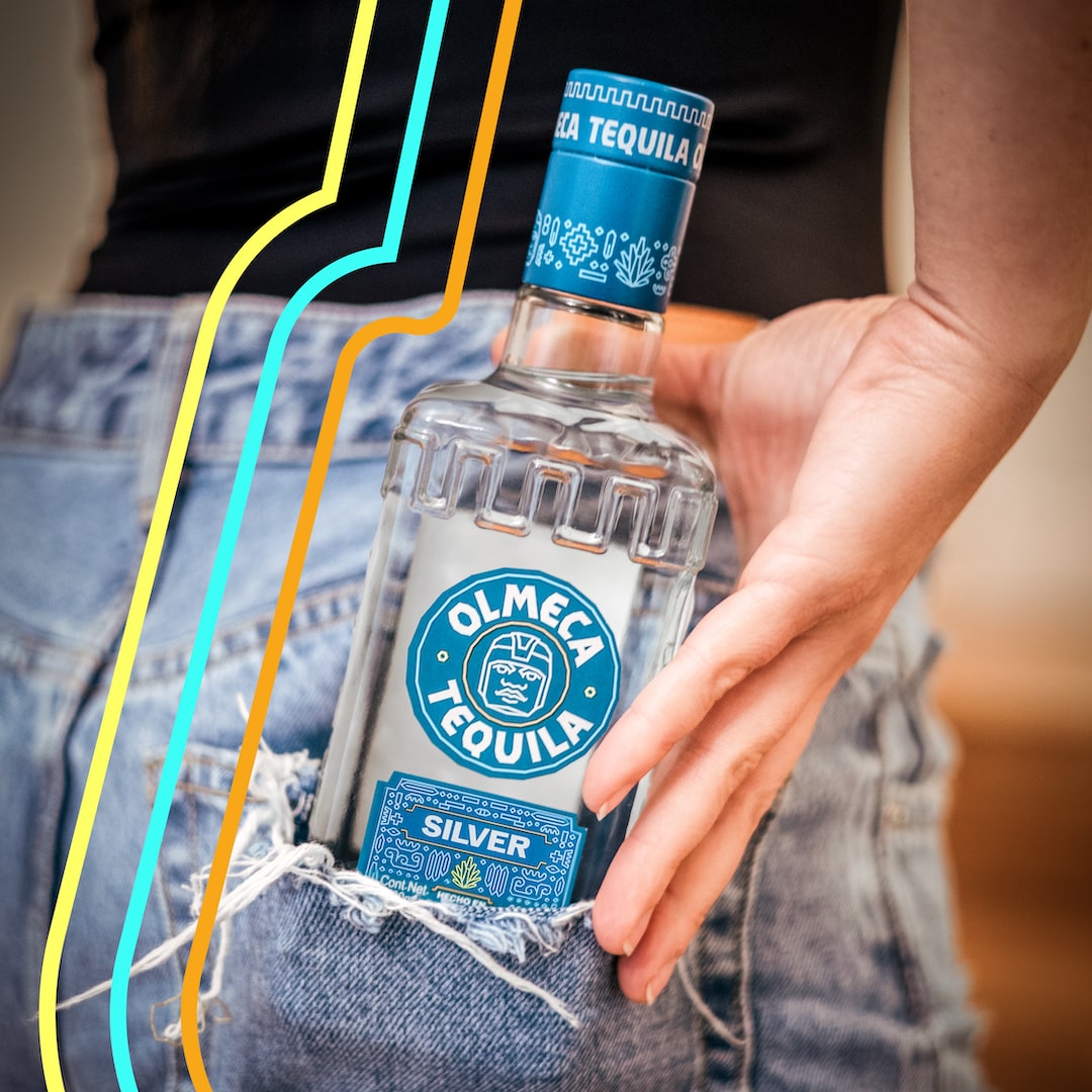 A bottle of Olmeca in a ripped jeans pocket